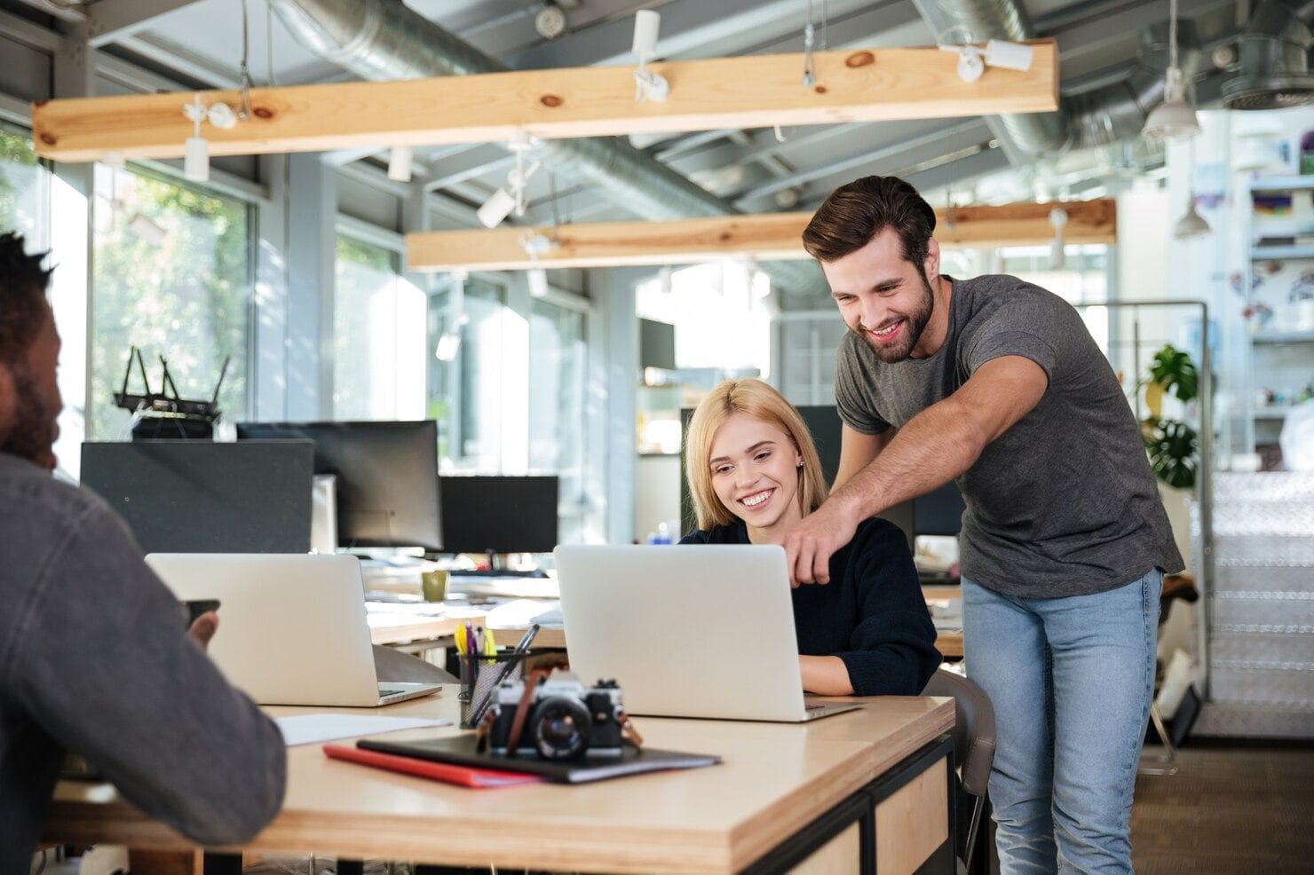 Team members collaborating at a laptop